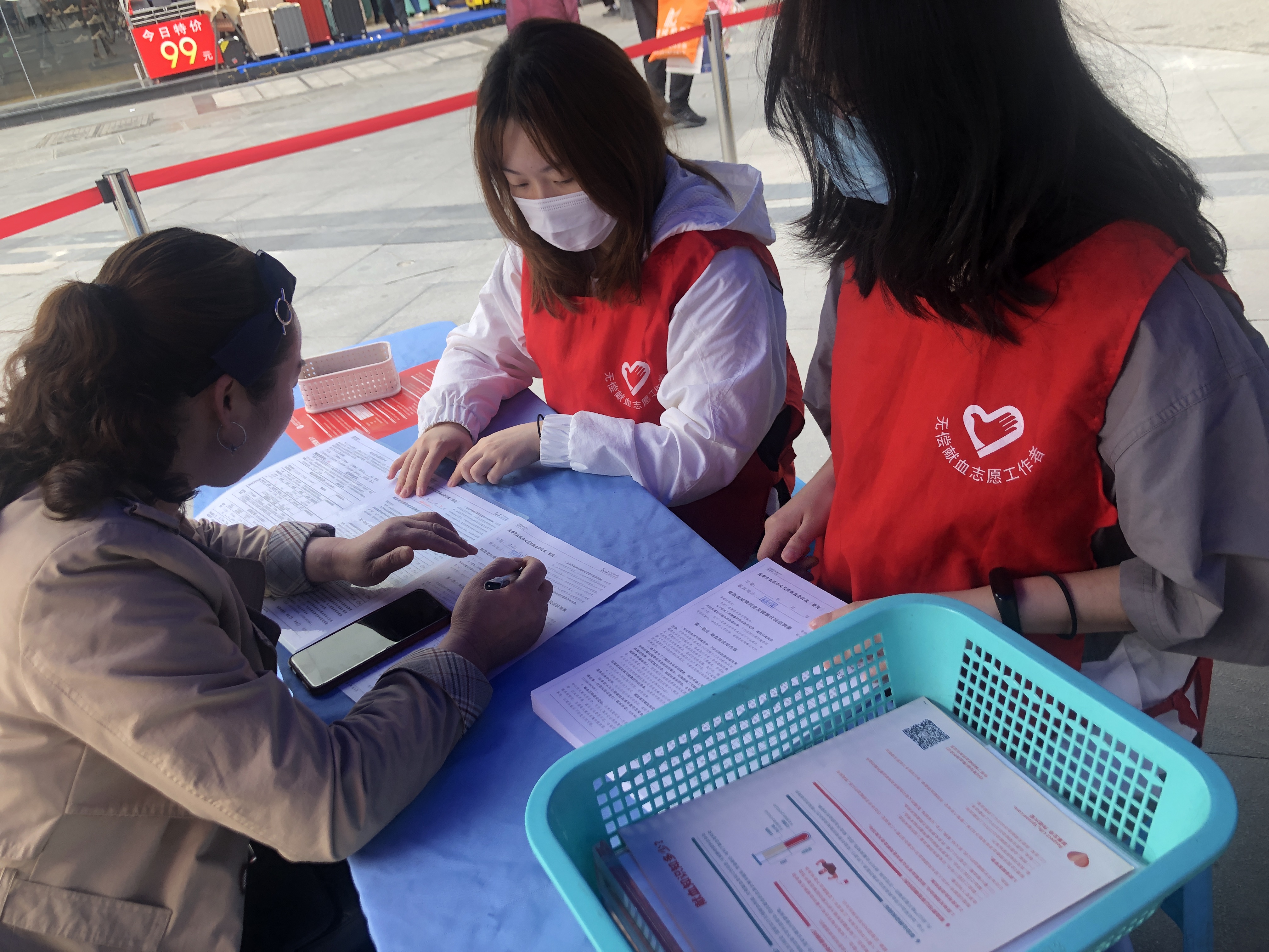 志愿者在引导献血者填写表格.jpg